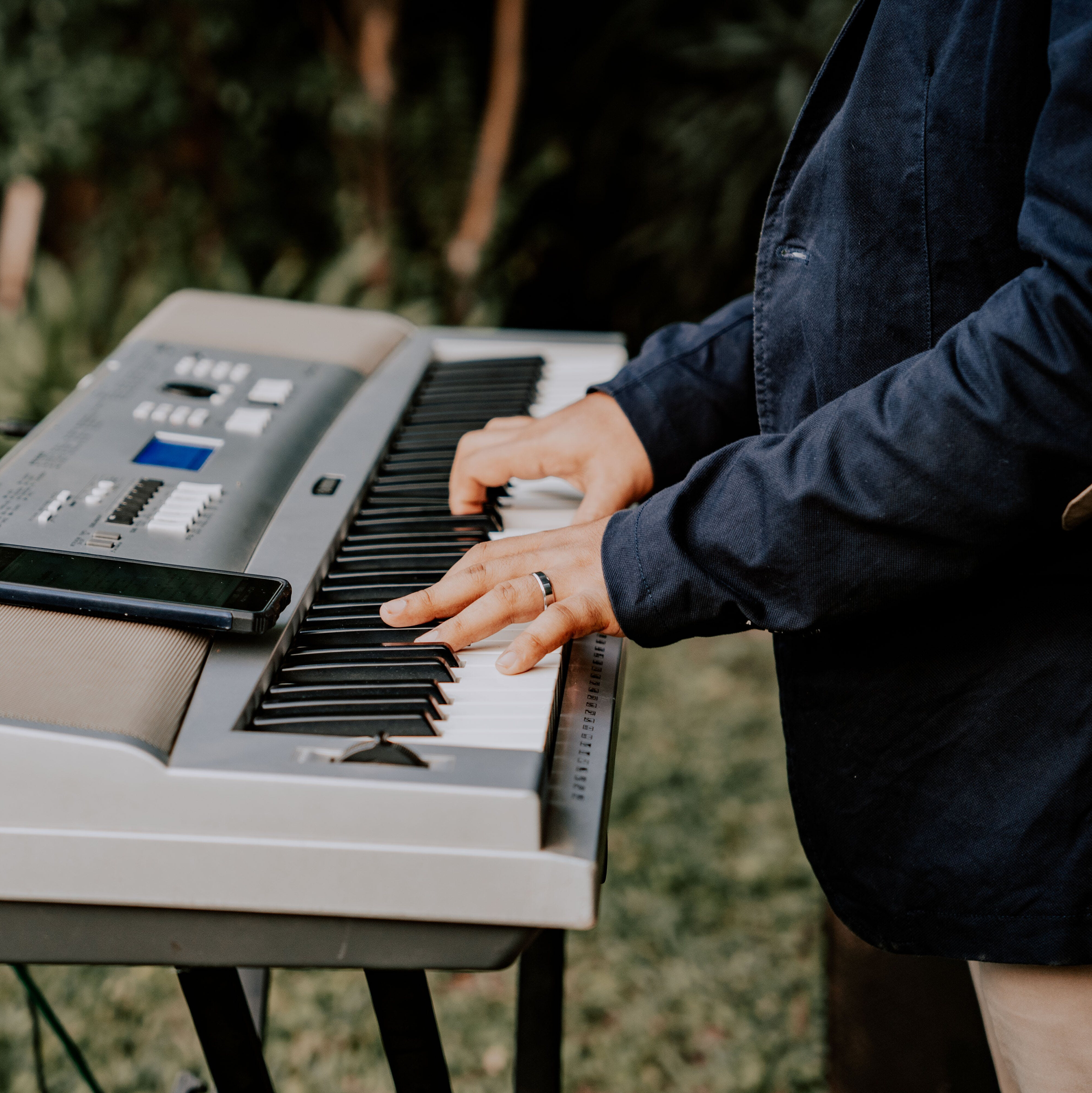 un pianoforte elettrico sta venendo suonato da delle mani di un uomo adulto